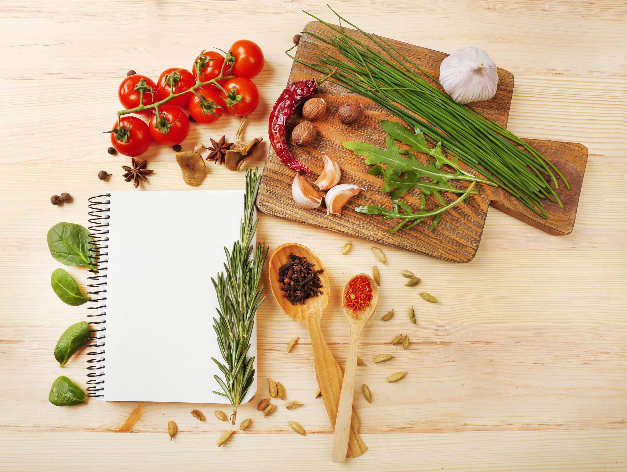 Tavolo rustico con ingredienti freschi e quaderno di ricette