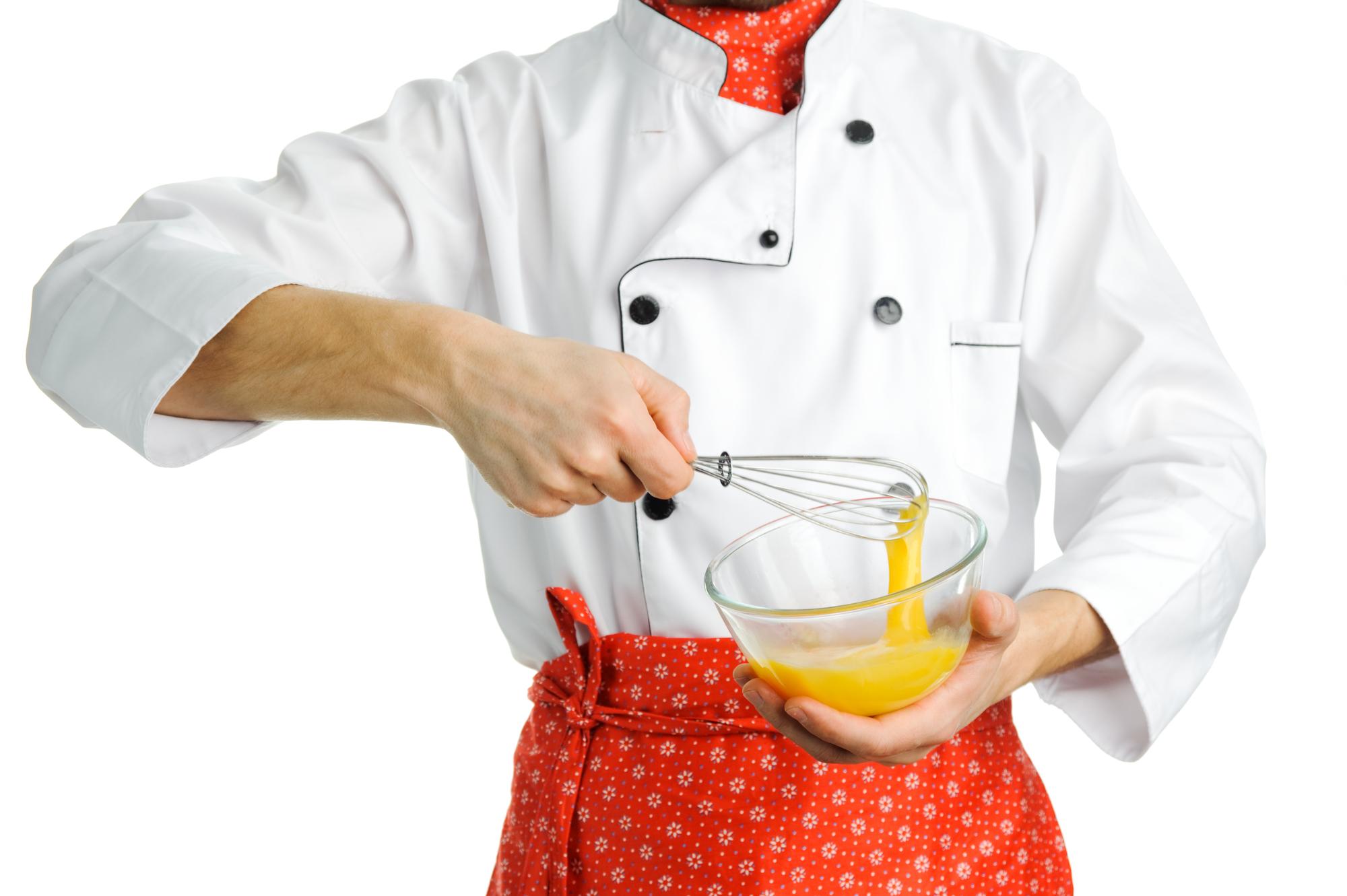 Chef che spadella su piano di lavoro caldo